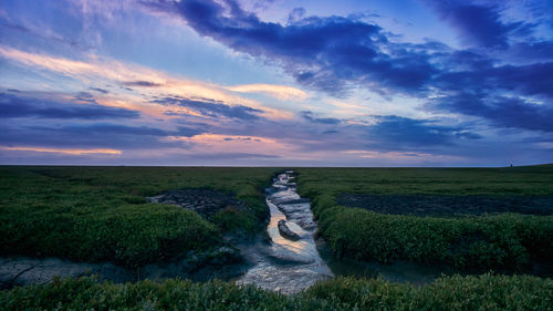 Scenic view of land against sky during sunset