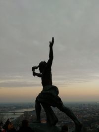 Silhouette of statue against sky during sunset