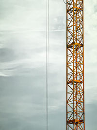 Low angle view of crane against sky