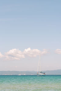 Sailboat sailing on sea against sky