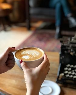 Woman holding a cup of latte coffee