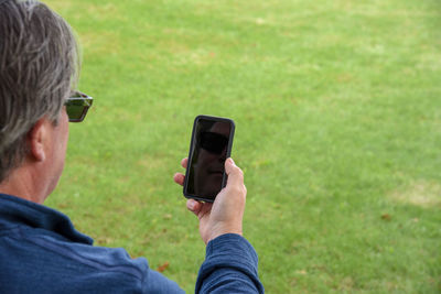 Rear view of man using mobile phone 