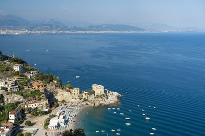 High angle view of city by sea against sky