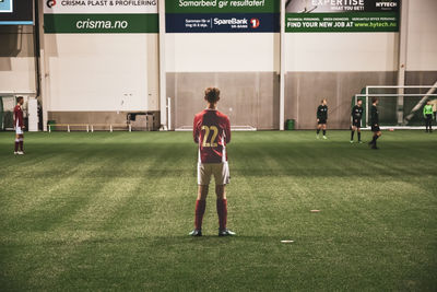 Full length rear view of man playing soccer