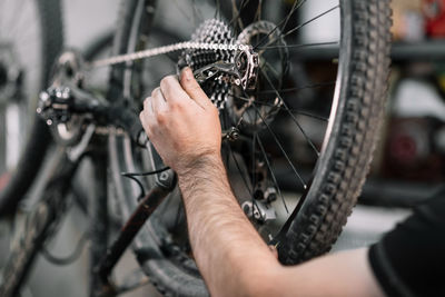 Cropped image of man repairing bicycle at workshop