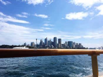 City at waterfront against cloudy sky