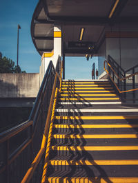 People on staircase in city against sky