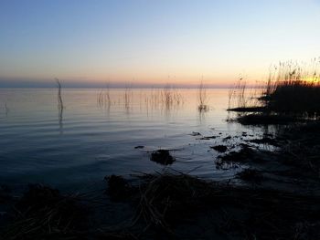 Scenic view of lake against sky at sunset