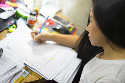 Midsection of woman reading book on table