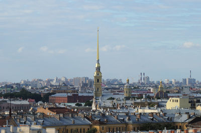 Buildings in city against cloudy sky