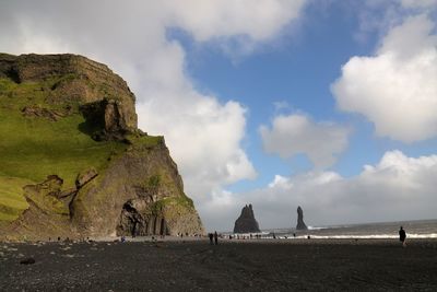 Scenic view of beach against cloudy sky