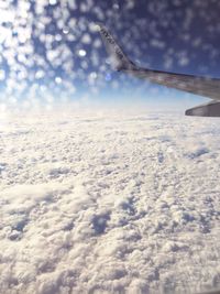 Airplane wing flying over cloudscape