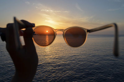 Amazing sunset with the sea and the cliffs in the background seen through sunglasses