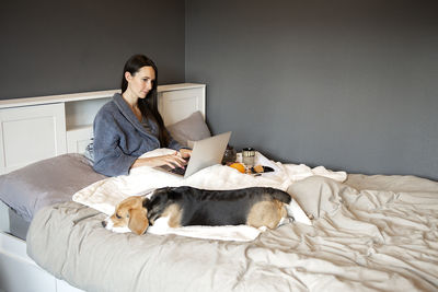 Woman using laptop in bedroom