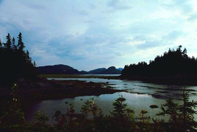 Scenic view of lake against cloudy sky