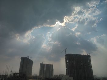 Low angle view of buildings against cloudy sky