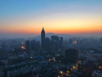 High angle view of buildings in city during sunset