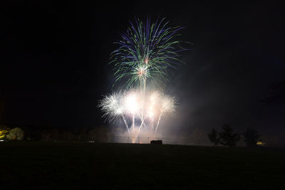 Low angle view of firework display at night