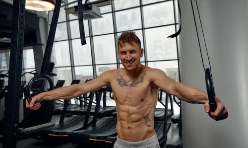 Portrait of young man exercising in gym