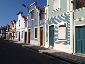 Street by buildings against sky