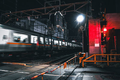 Train passing through a railroad crossing at night