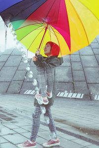 Full length of person holding umbrella standing in rainy season