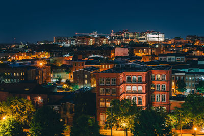 High angle view of illuminated buildings against sky at night