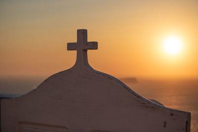 Close-up of cross on beach against sky during sunset