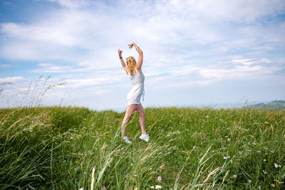 Woman standing on field against sky