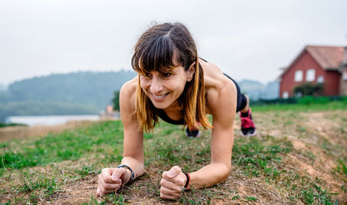 Young woman smiling while standing on field