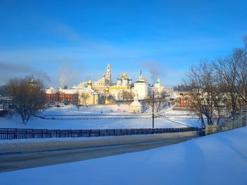 Canal amidst buildings against sky during winter