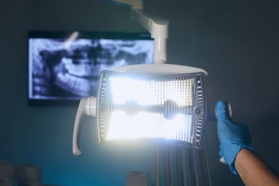 Modern dental surgery. dentist adjusting lamp against x-ray of teeth in dental clinic.