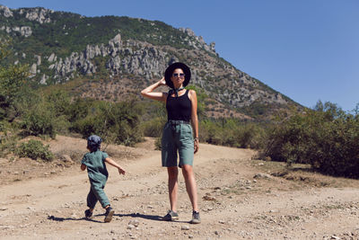 Child boy walks with his mother in the mountains in the summer