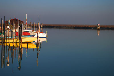 Boats moored in calm lake