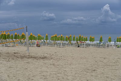 Beach umbrellas on shore against sky