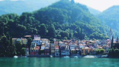 Houses by river against sky