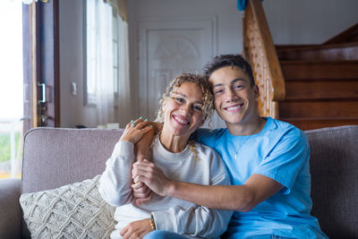 Portrait of happy friends sitting on sofa