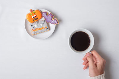 Hand holding coffee cup against white background