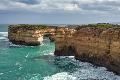 Scenic view of rock formation in sea against sky