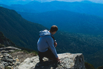 Rear view of man walking on mountain road