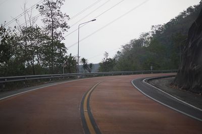 Road amidst trees against sky