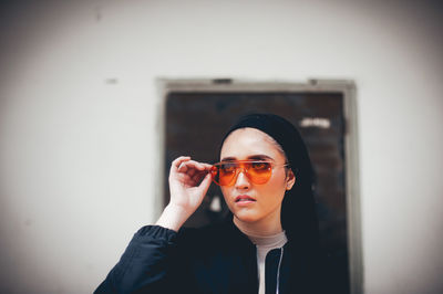 Smiling woman standing against wall