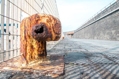 Old rusty metal fence against sky in city