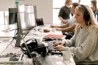 Female colleague working on computer at workplace