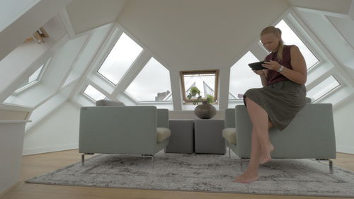 Woman sitting on sofa at home