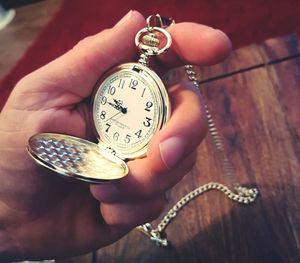 Close-up of hand holding clock