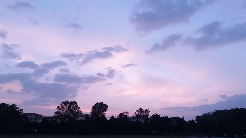 Silhouette of trees against cloudy sky