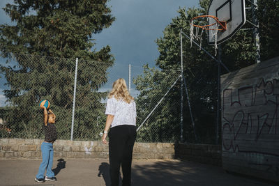 Mother and daughter playing basketball outdoors