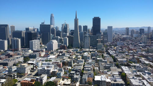 Aerial view of buildings in city against clear sky