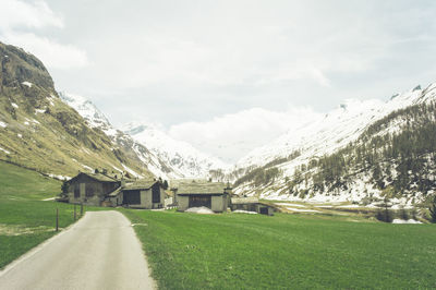 Road by mountains against sky